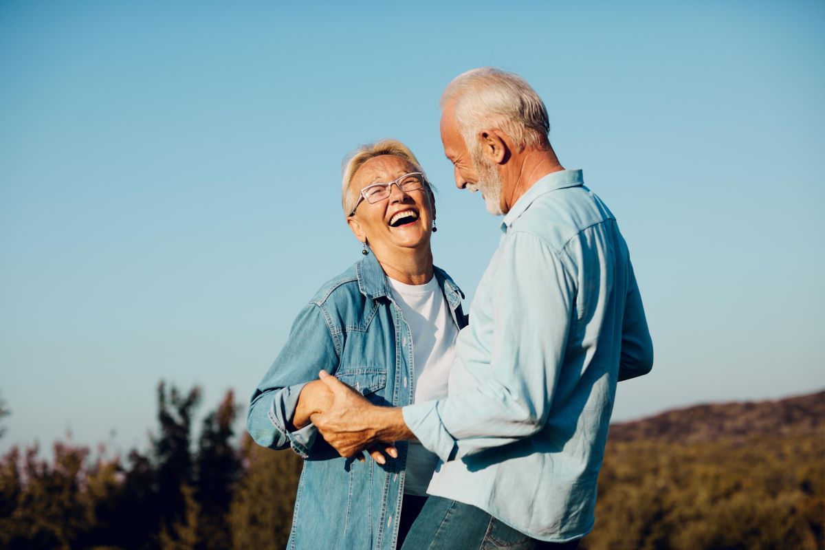 Senior couple smiling holding hands