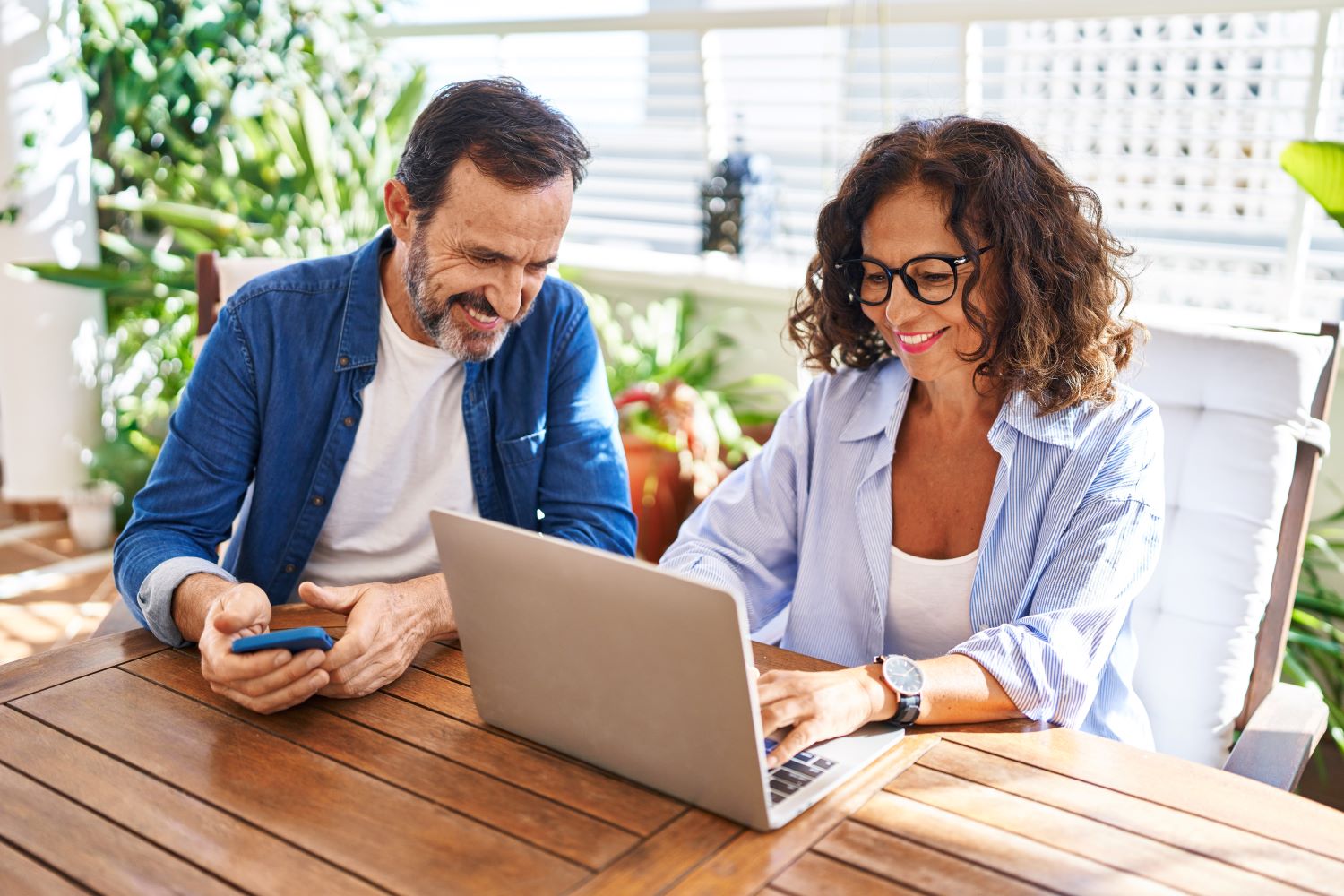 Couple looking at a laptop at their home patio